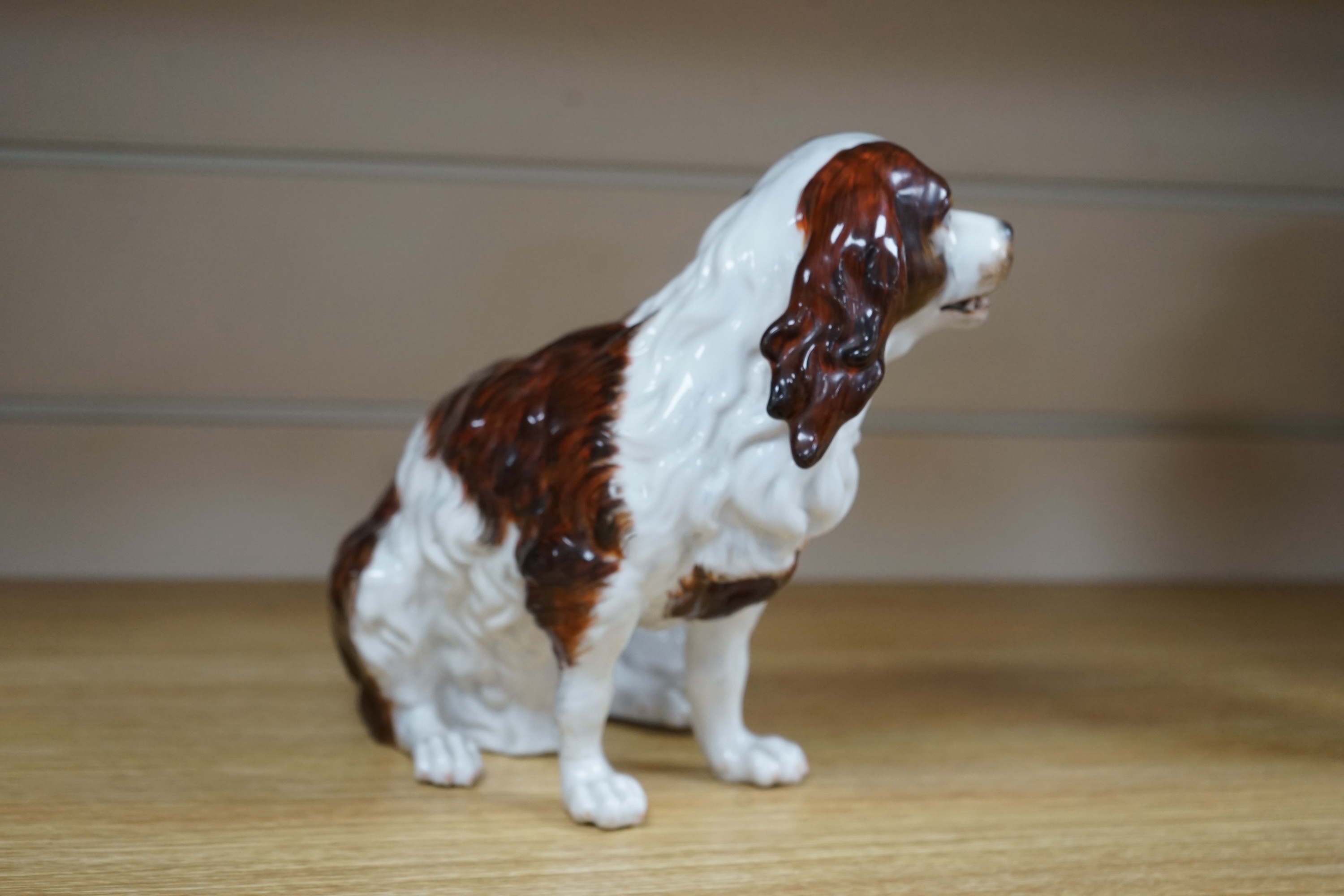 A Sitzendorf porcelain model of seated Spaniel, 21cm. Condition - repaired paw